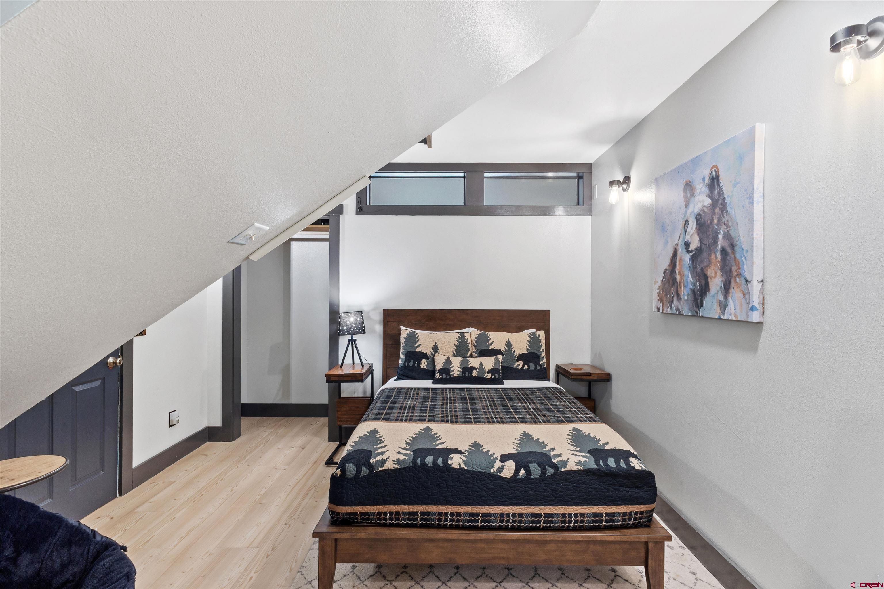301 West 3rd Street Creede, CO 81130 - Photo 17 of 28 a bed sitting in a bedroom and painting on the wall