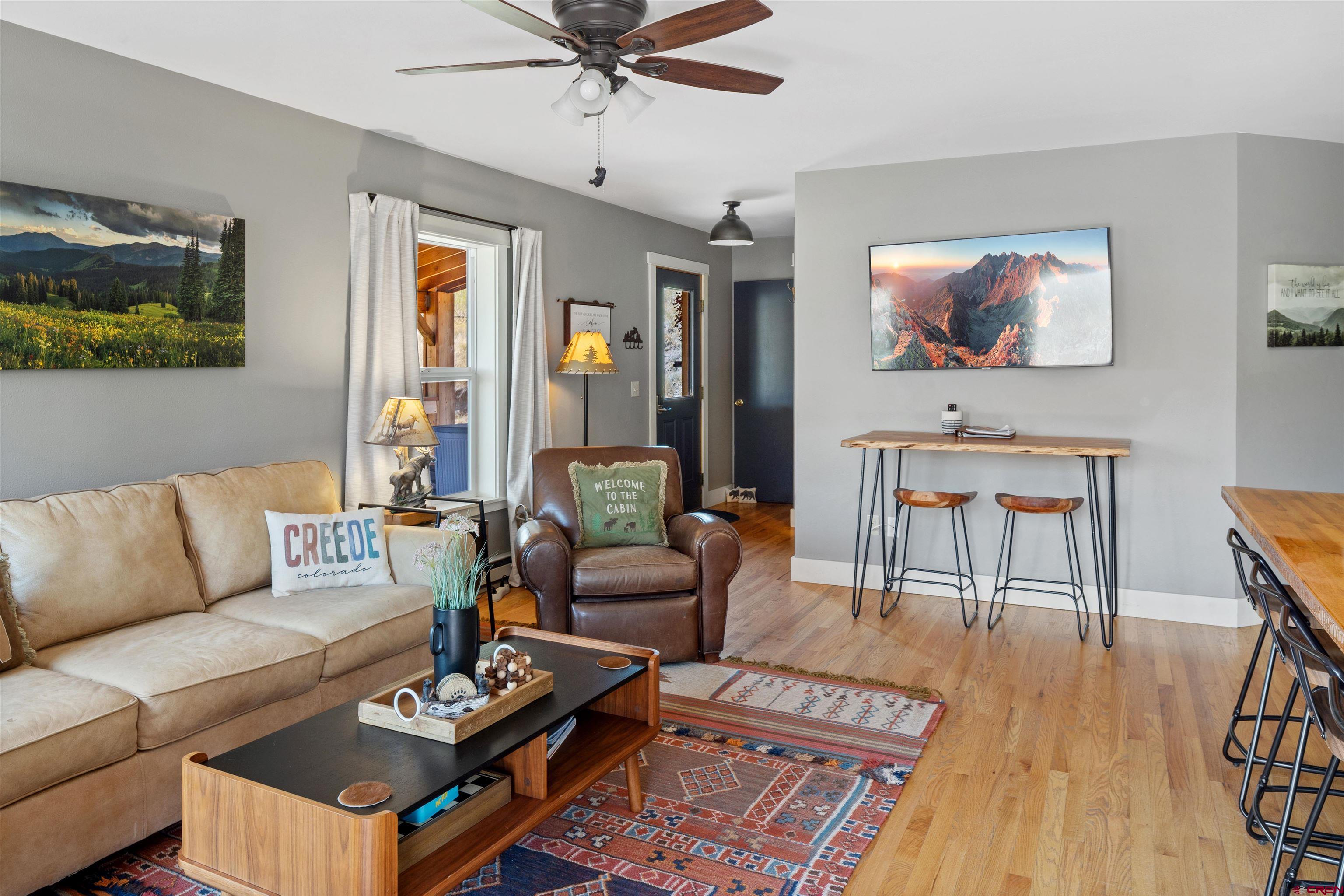 301 West 3rd Street Creede, CO 81130 - Photo 4 of 28 a living room with furniture a wooden floor and a flat screen tv