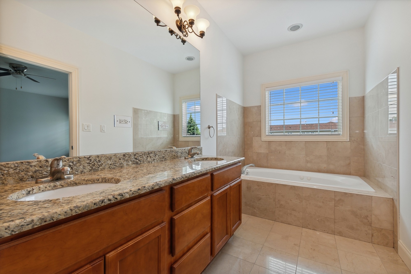 10028 South Roberts Road Palos Hills, IL 60465 - Photo 7 of 15 a bathroom with a granite countertop sink a mirror and a bathtub