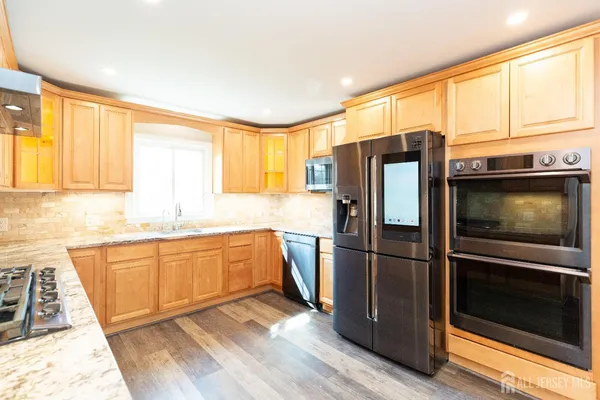 a kitchen with stainless steel appliances wooden floors and wooden cabinets