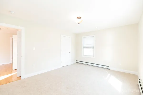 an empty room with a window and a ceiling fan