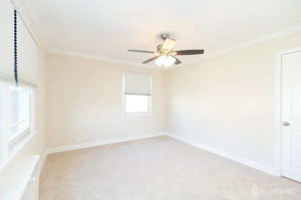 an empty room with windows and fan