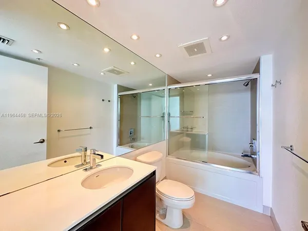 a bathroom with a sink mirror toilet and bathtub
