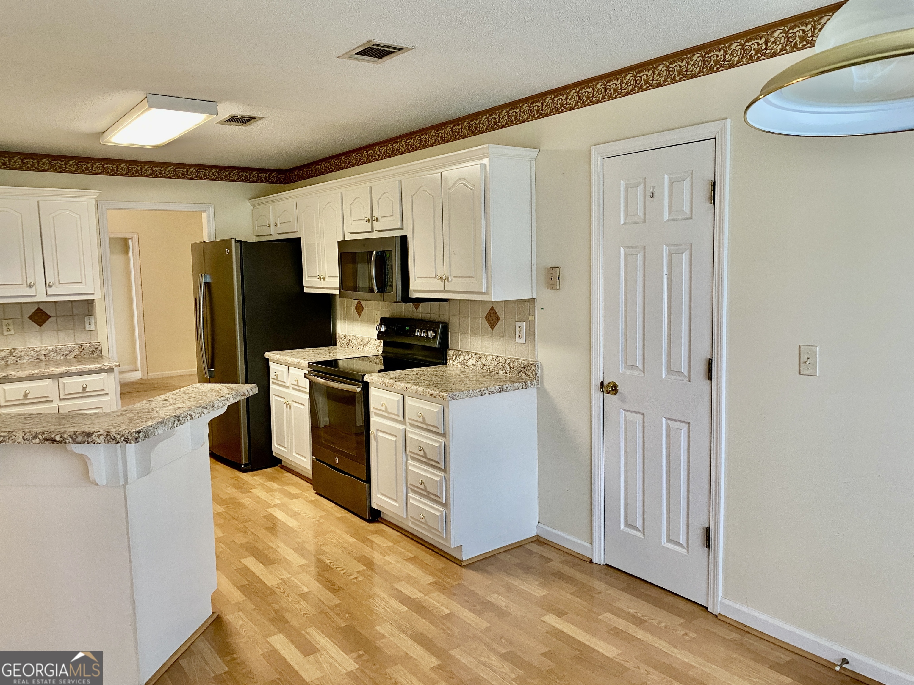 38 Boulder Drive Northwest Rome, GA 30165 - Photo 6 of 21 a kitchen with stainless steel appliances white cabinets and a refrigerator