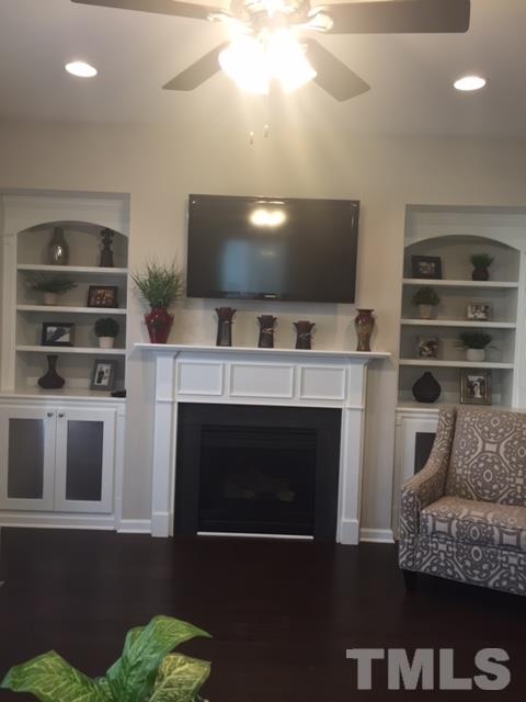 738 Wickham Ridge Road Apex, NC 27539 - Photo 13 of 23 a living room with furniture a flat screen tv and a fireplace