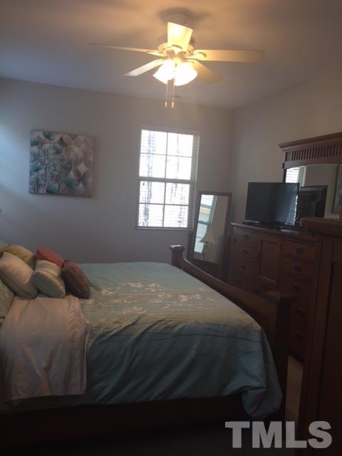 738 Wickham Ridge Road Apex, NC 27539 - Photo 16 of 23 a bedroom with a bed and a chandelier
