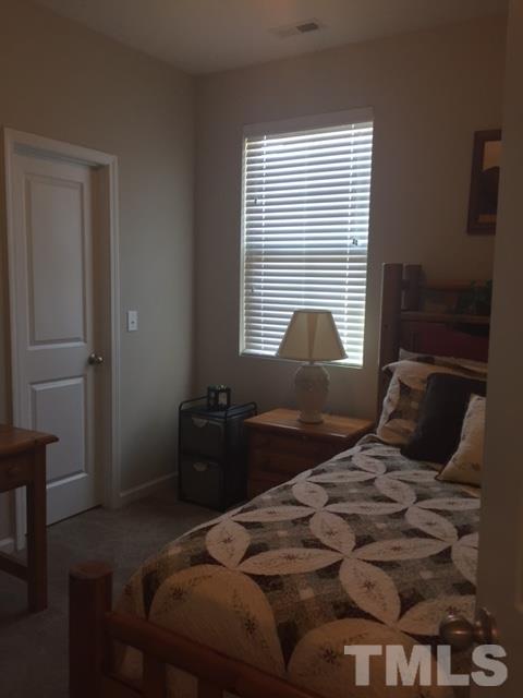 738 Wickham Ridge Road Apex, NC 27539 - Photo 19 of 23 a bedroom with a bed and a window