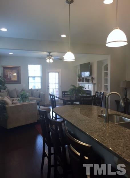 738 Wickham Ridge Road Apex, NC 27539 - Photo 3 of 23 a kitchen with granite countertop a table chairs stove and sink