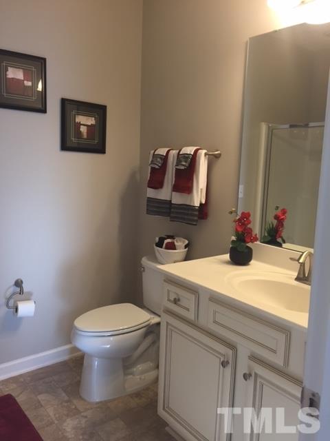 738 Wickham Ridge Road Apex, NC 27539 - Photo 8 of 23 a bathroom with a toilet sink and mirror