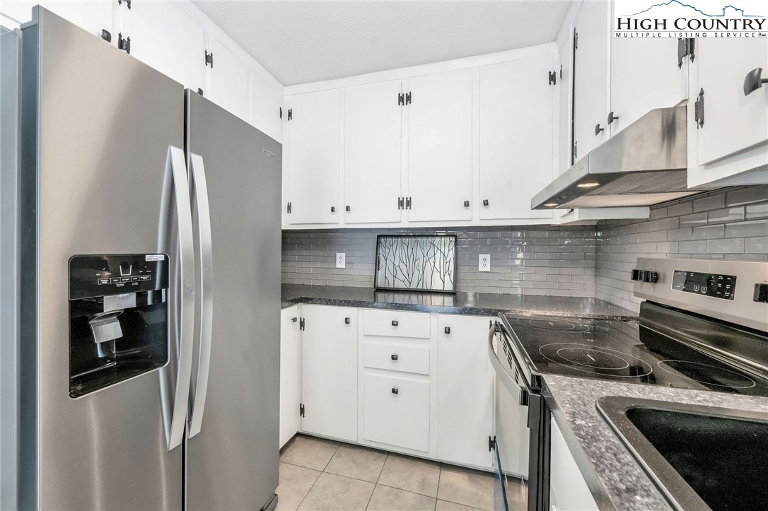 393 Carter Miller Road Todd, NC 28684 - Photo 38 of 48 a kitchen with stainless steel appliances white cabinets and white appliances
