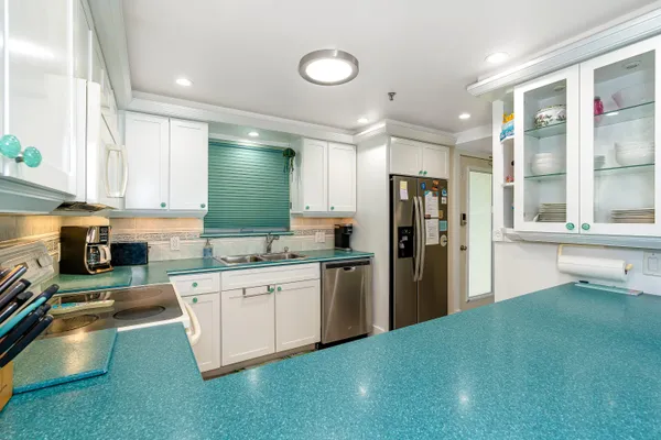 a kitchen with stainless steel appliances granite countertop a refrigerator and a sink