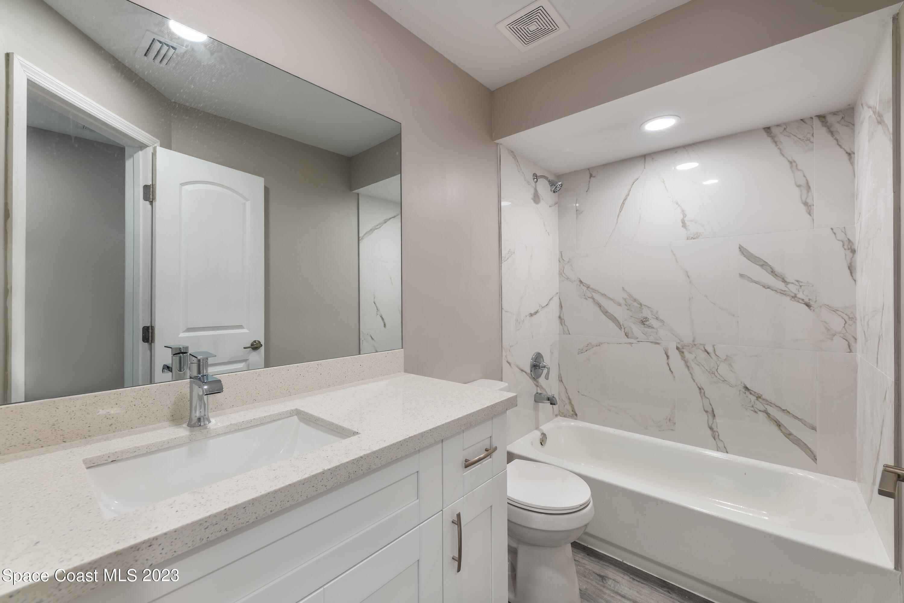 6641 Cecil Road Cocoa, FL 32927 - Photo 8 of 28 a bathroom with a double vanity sink toilet mirror and bathtub