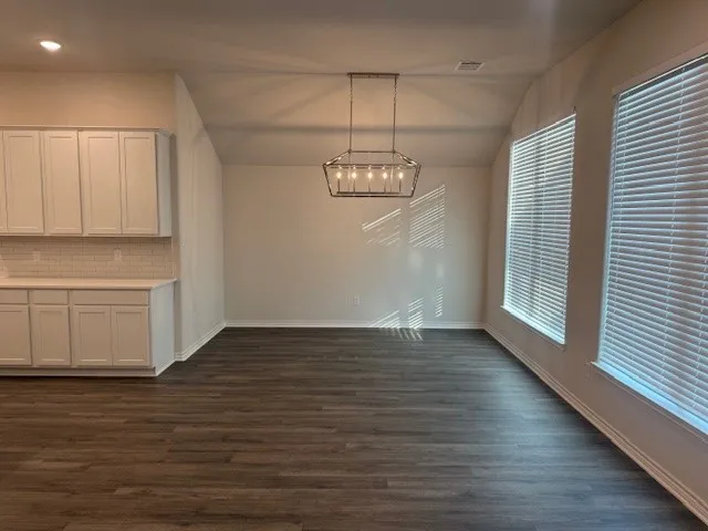 a view of a kitchen with wooden floor and a window