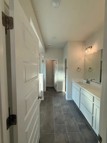a large bathroom with a glass shower door a sink and a mirror