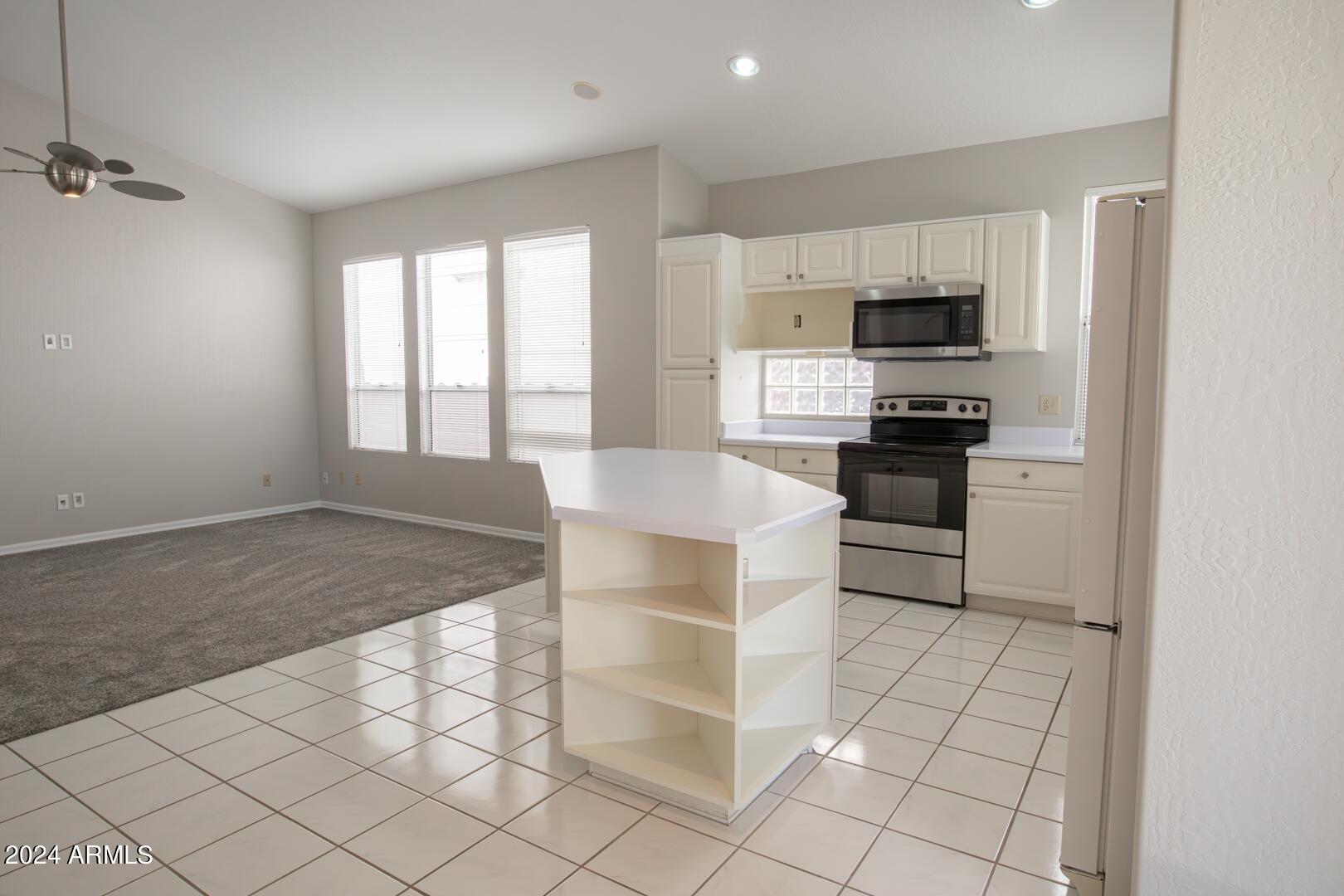 16051 South 24th Place Phoenix, AZ 85048 - Photo 14 of 42 a kitchen with stainless steel appliances a stove a sink and white cabinets