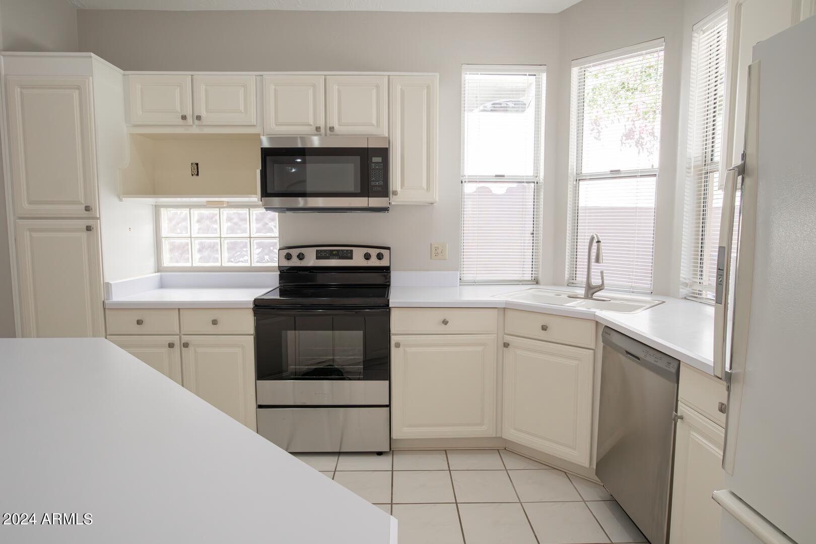 16051 South 24th Place Phoenix, AZ 85048 - Photo 15 of 42 a kitchen with a stove a sink and a microwave