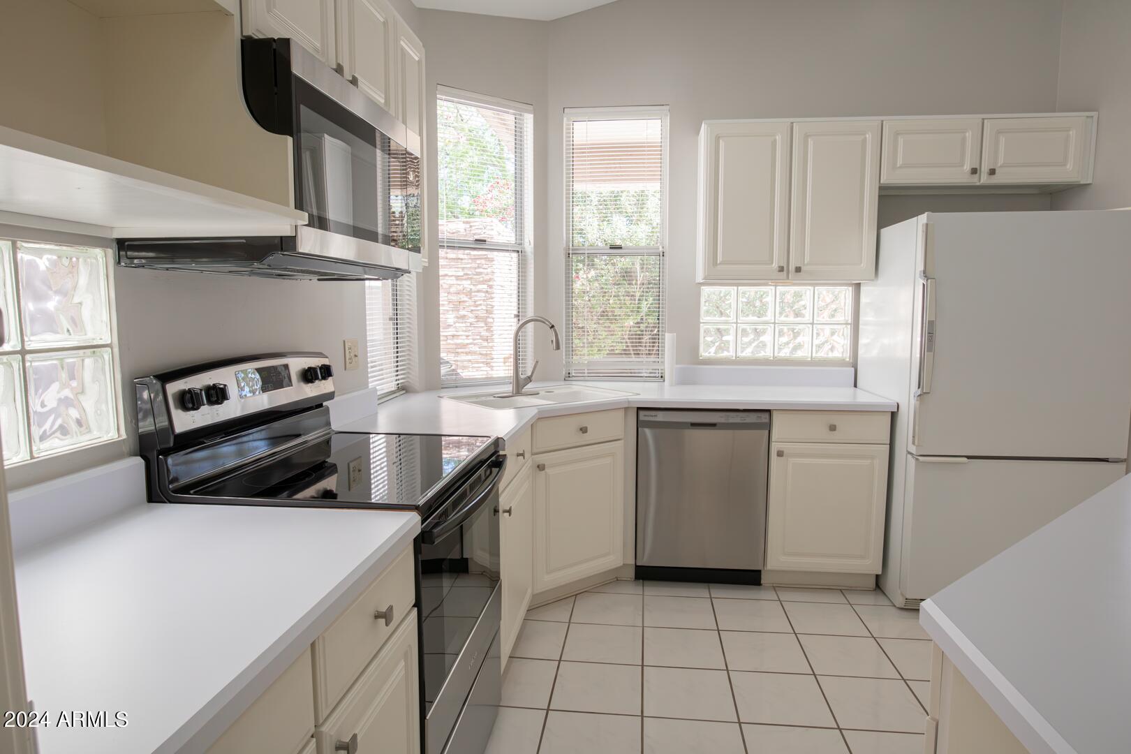 16051 South 24th Place Phoenix, AZ 85048 - Photo 16 of 42 a kitchen with a white cabinets and white appliances
