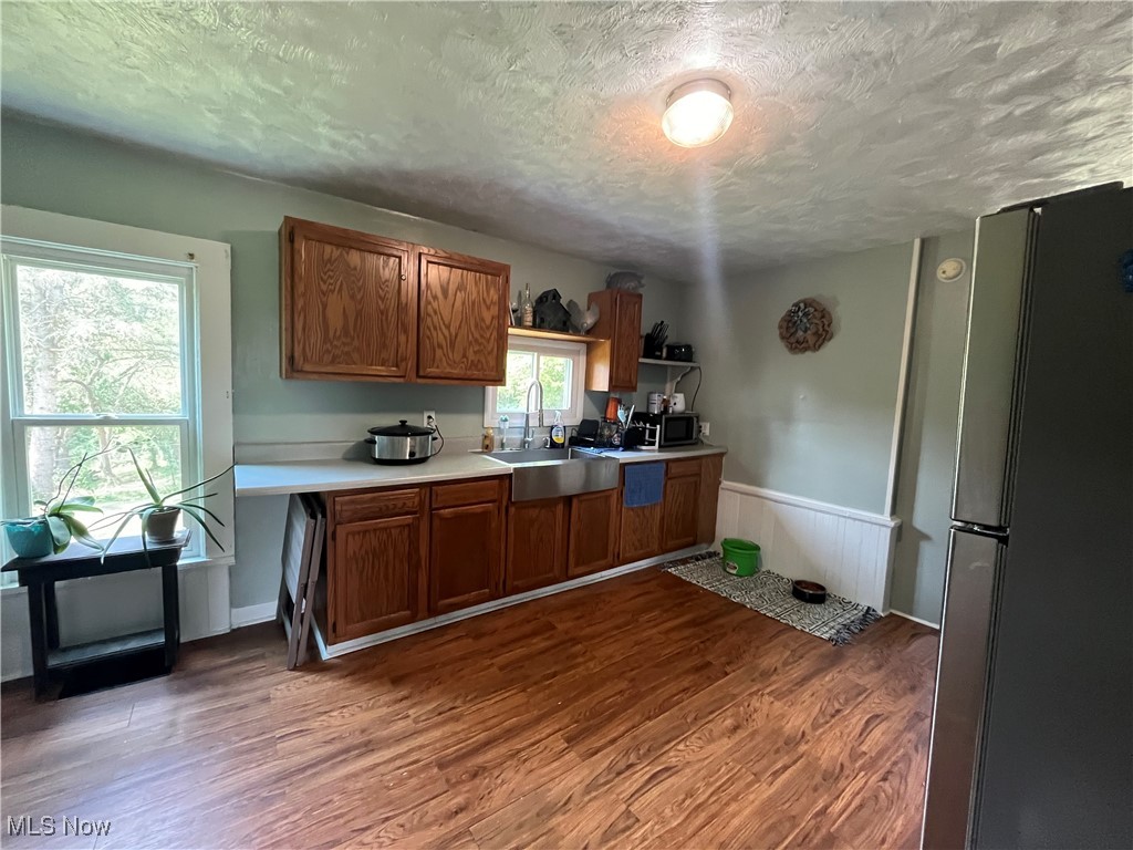 73475 Broadhead Road Kimbolton, OH 43749 - Photo 13 of 30 Kitchen with sink, stainless steel appliances, hardwood / wood-style flooring, and a textured ceiling