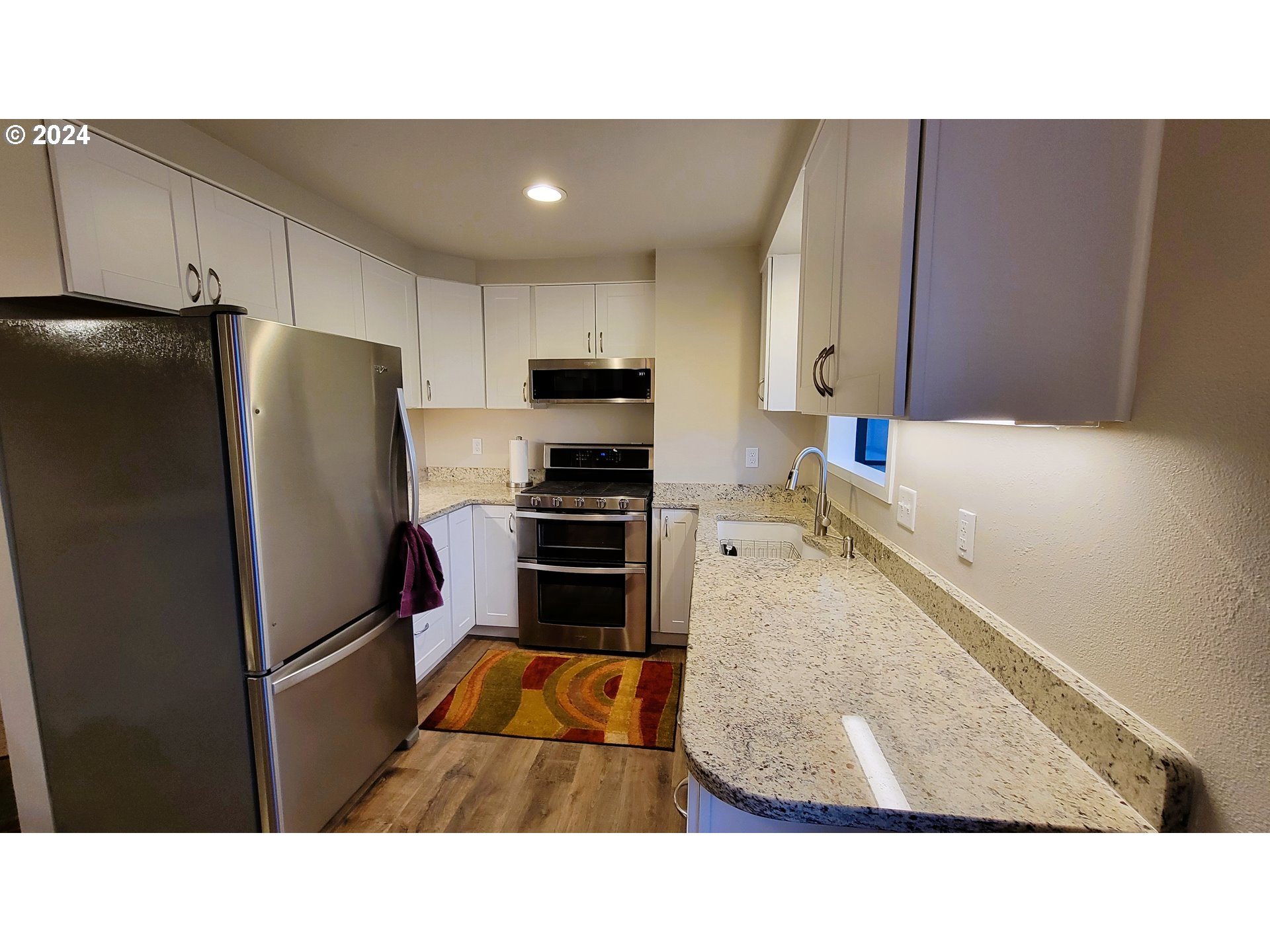 2564 Nova Street Springfield, OR 97477 - Photo 6 of 29 a kitchen with stainless steel appliances kitchen island granite countertop a refrigerator a stove and a sink