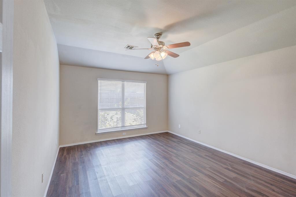 7310 Northpoint Drive Rowlett, TX 75089 - Photo 11 of 32 an empty room with wooden floor fan and windows