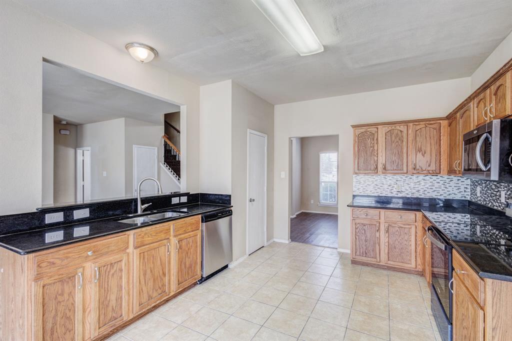 7310 Northpoint Drive Rowlett, TX 75089 - Photo 21 of 32 a kitchen with granite countertop a sink and a stove