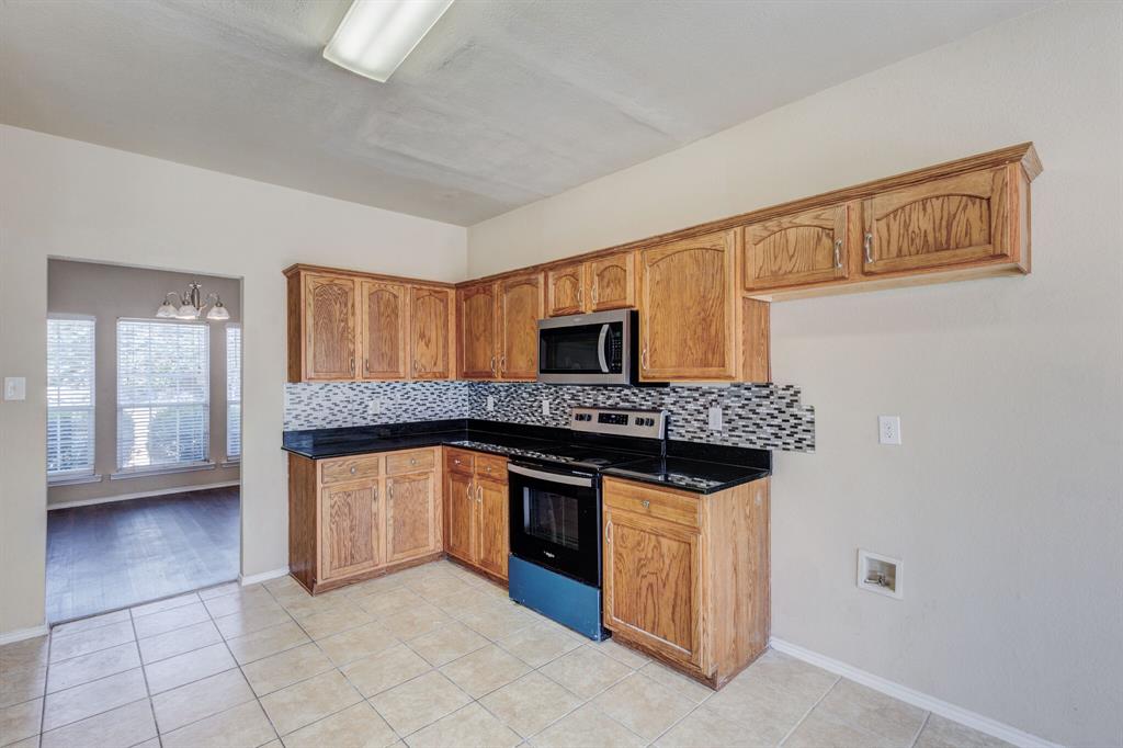 7310 Northpoint Drive Rowlett, TX 75089 - Photo 22 of 32 a kitchen with stainless steel appliances granite countertop a stove and a sink