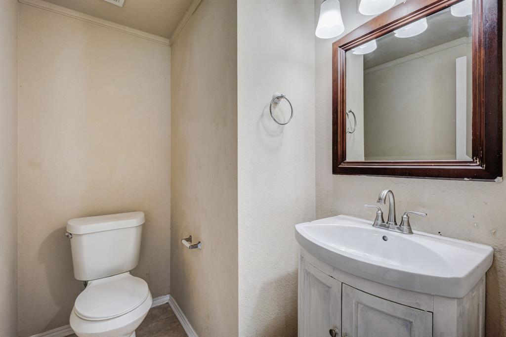 7310 Northpoint Drive Rowlett, TX 75089 - Photo 10 of 32 a bathroom with a toilet a sink and mirror