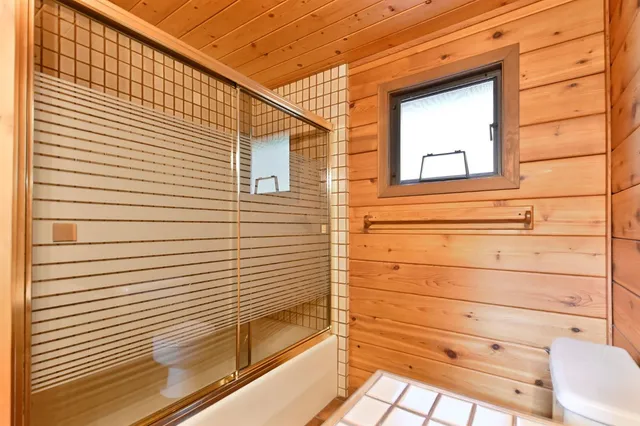 a view of a street with a yard and large trees