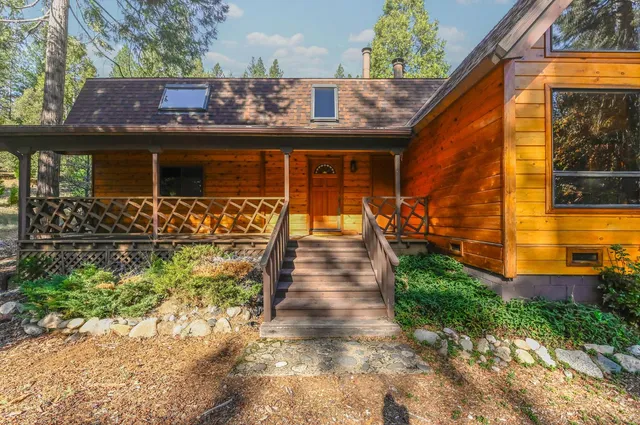 a view of a yard with chairs and table in the patio