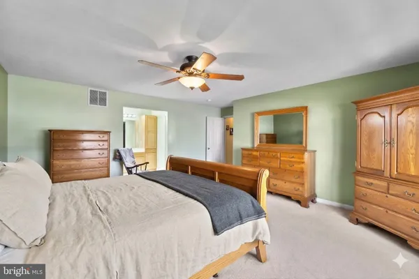 a bedroom with a bed and dresser with chair