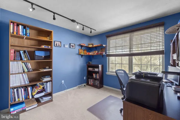a view of a workspace with furniture and a bookshelf