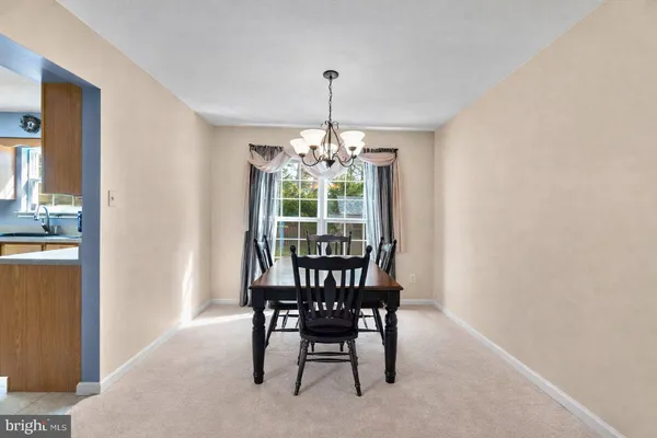 a dining room with furniture a chandelier and window
