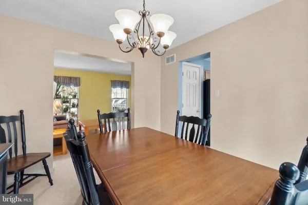 a view of a dining room with furniture and chandelier