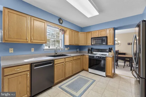 a kitchen with stainless steel appliances granite countertop a stove sink and microwave