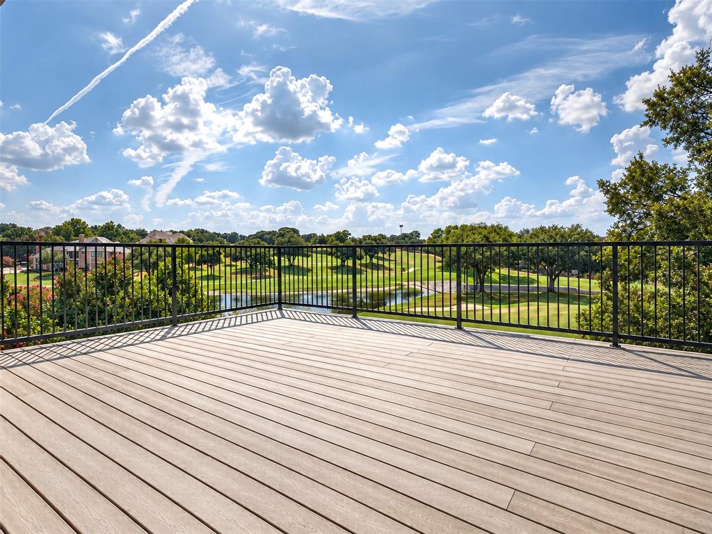 6809 Cedar Ridge Court Plano, TX 75093 - Photo 31 of 38 Expansive outdoor deck with composite decking and black metal railing, overlooking a golf course with a water feature and mature trees