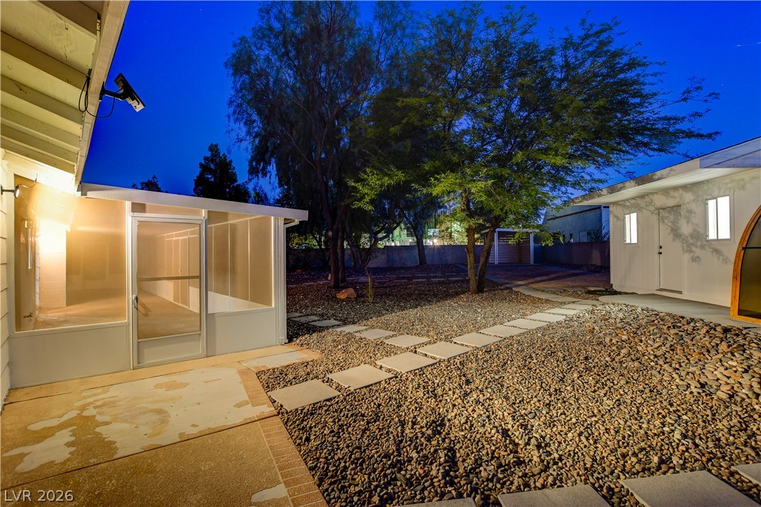 7631 Bermuda Road Las Vegas, NV 89123 - Photo 58 of 64 A private outdoor space with a screened porch and a pathway leading through a rock garden.
