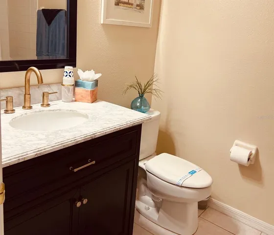a bathroom with a granite countertop sink and a toilet