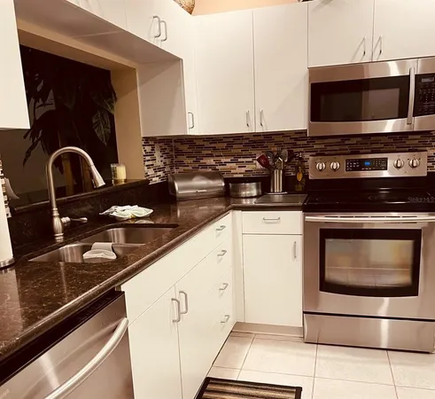 a kitchen with granite countertop a stove and a microwave