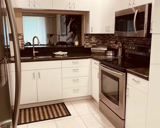 a kitchen with granite countertop a sink and a stove