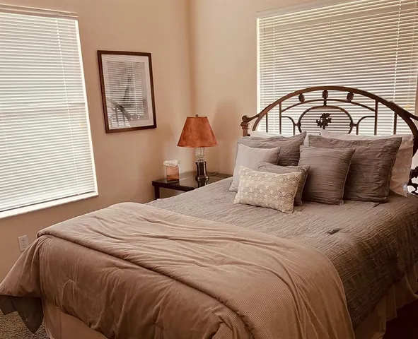 a bedroom with a bed and a painting on the wall