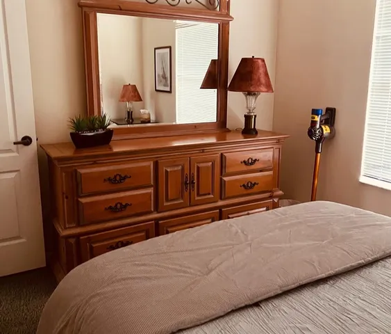 a bedroom with a bed and a mirror on dresser