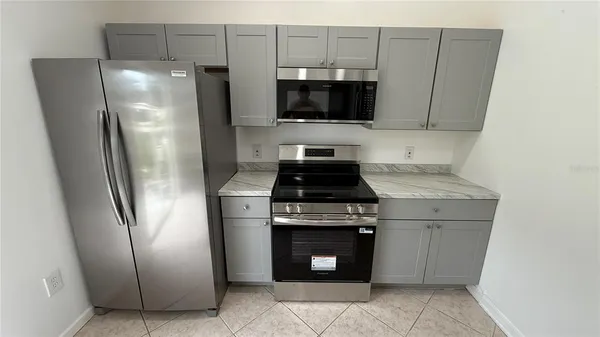 a kitchen with stainless steel appliances granite countertop a refrigerator a stove a sink and a oven