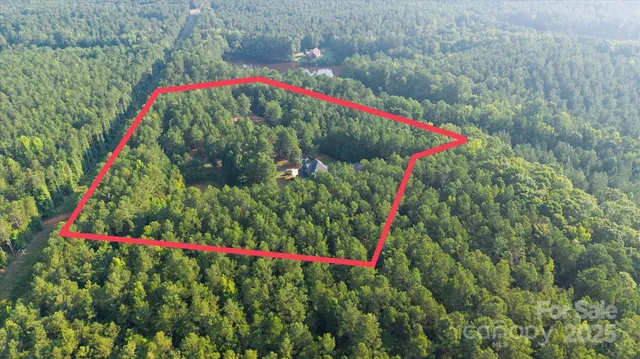 an aerial view of a house with a yard and trees
