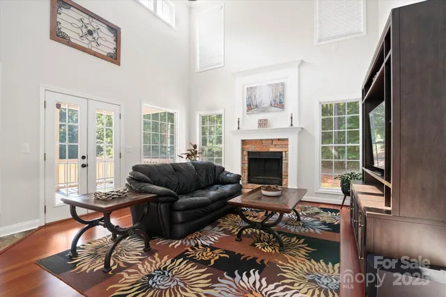 a living room with furniture a couch and a dining table with wooden floor