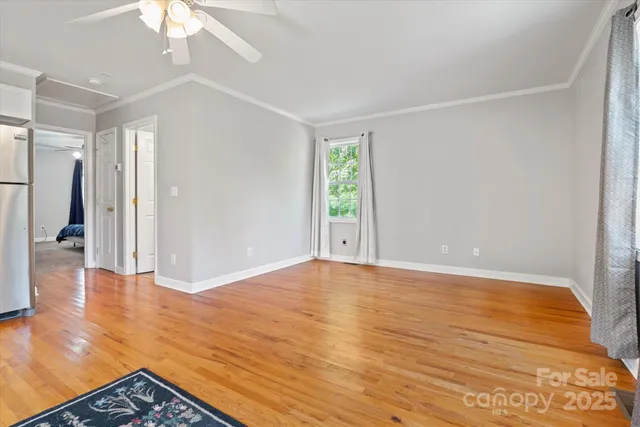 a view of a kitchen with wooden floor electronic appliances and cabinets