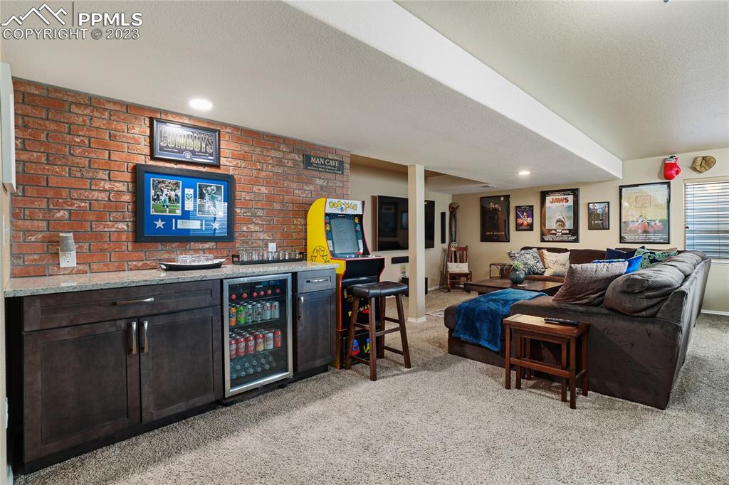 6435 Coyote Ridge Court Colorado Springs, CO 80923 - Photo 32 of 50 a living room with furniture and a flat screen tv