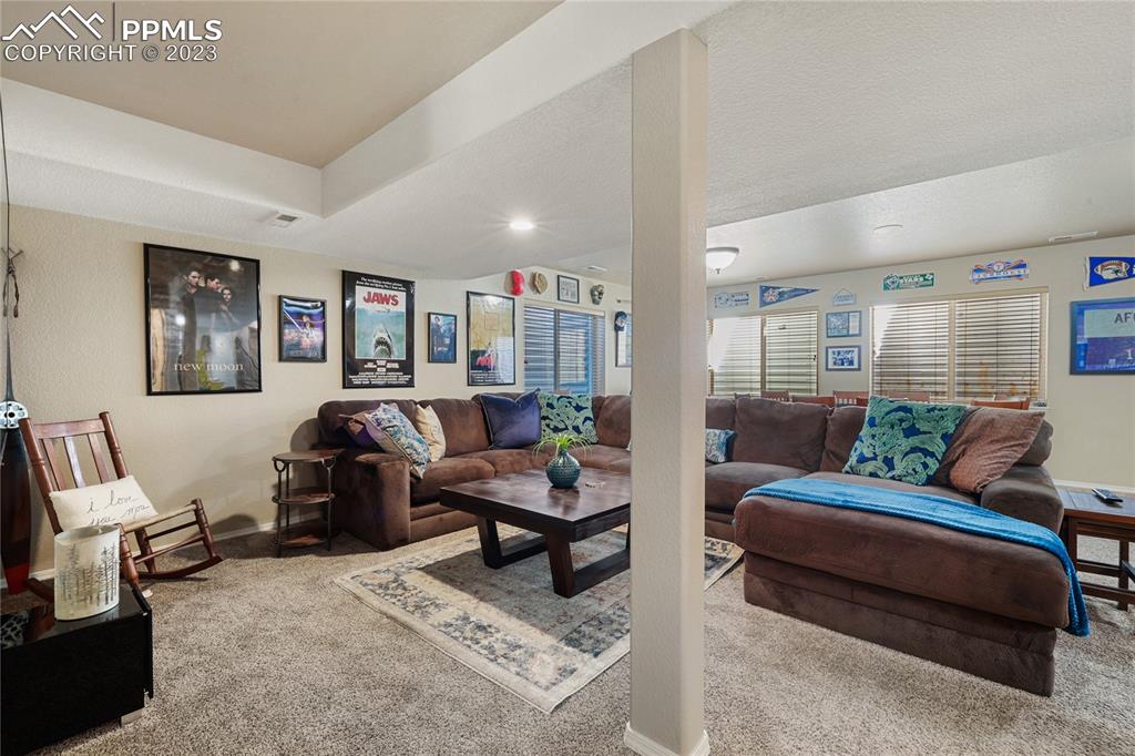 6435 Coyote Ridge Court Colorado Springs, CO 80923 - Photo 35 of 50 a living room with furniture and a rug