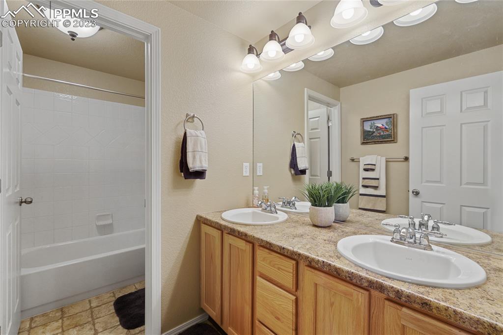 6435 Coyote Ridge Court Colorado Springs, CO 80923 - Photo 38 of 50 a bathroom with a sink a tub and a mirror