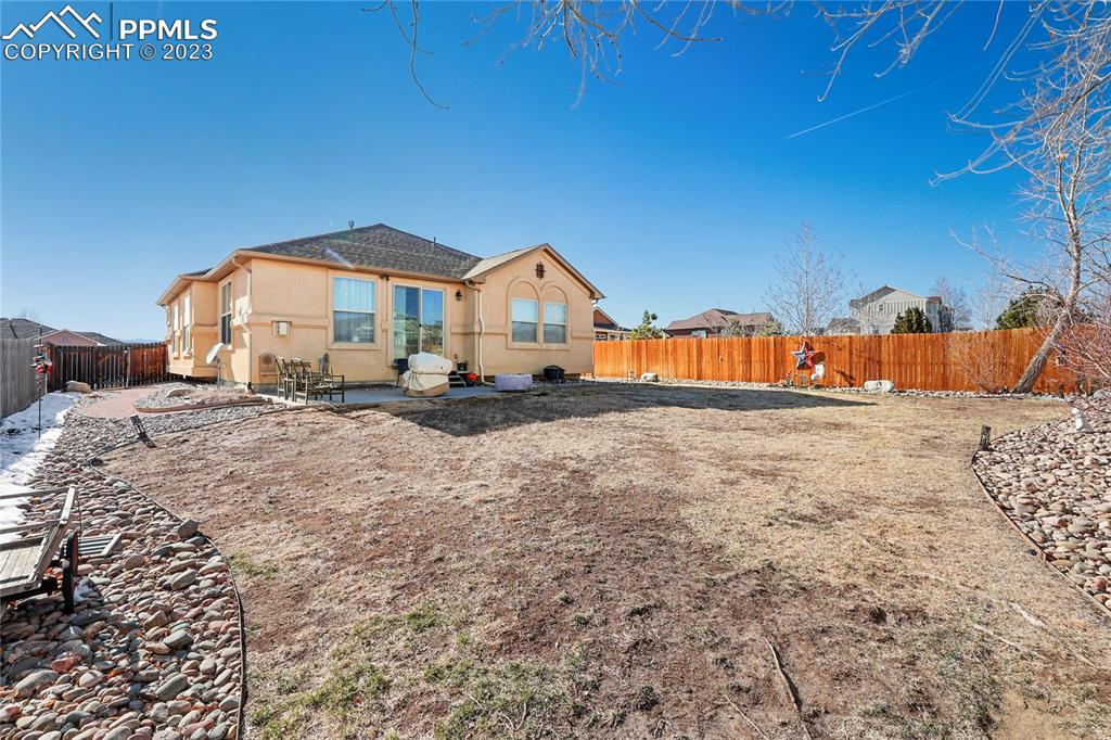 6435 Coyote Ridge Court Colorado Springs, CO 80923 - Photo 48 of 50 a view of a house with a yard