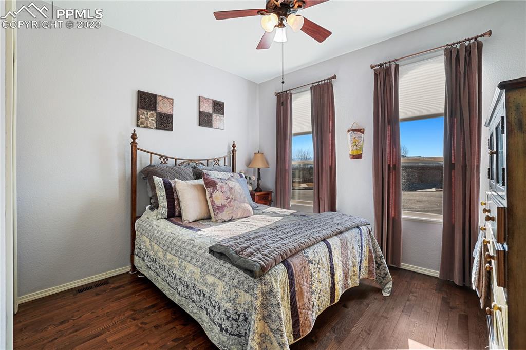 6435 Coyote Ridge Court Colorado Springs, CO 80923 - Photo 7 of 50 a bedroom with a bed and a chandelier